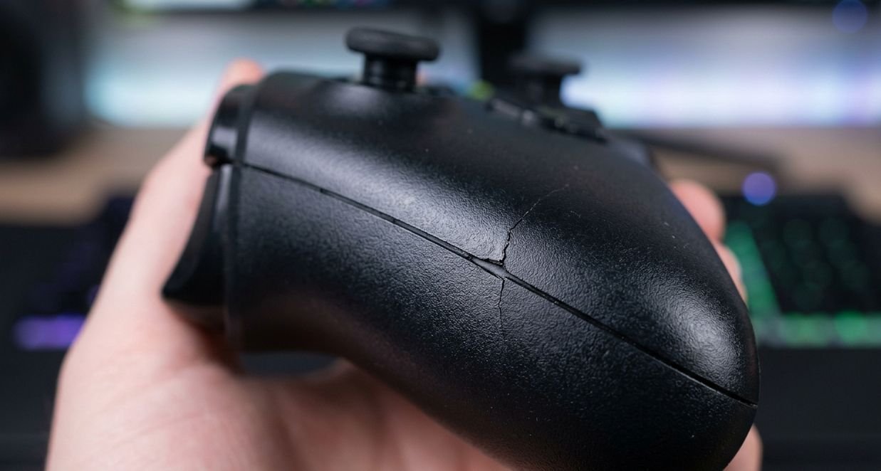 Close-up of controller shell cracking along the handle seam from grip pressure